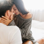 девушка сидит на коленях у парня и держит руками за шею