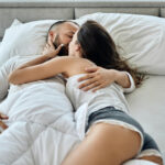 пара лежит в обнимку и целуется